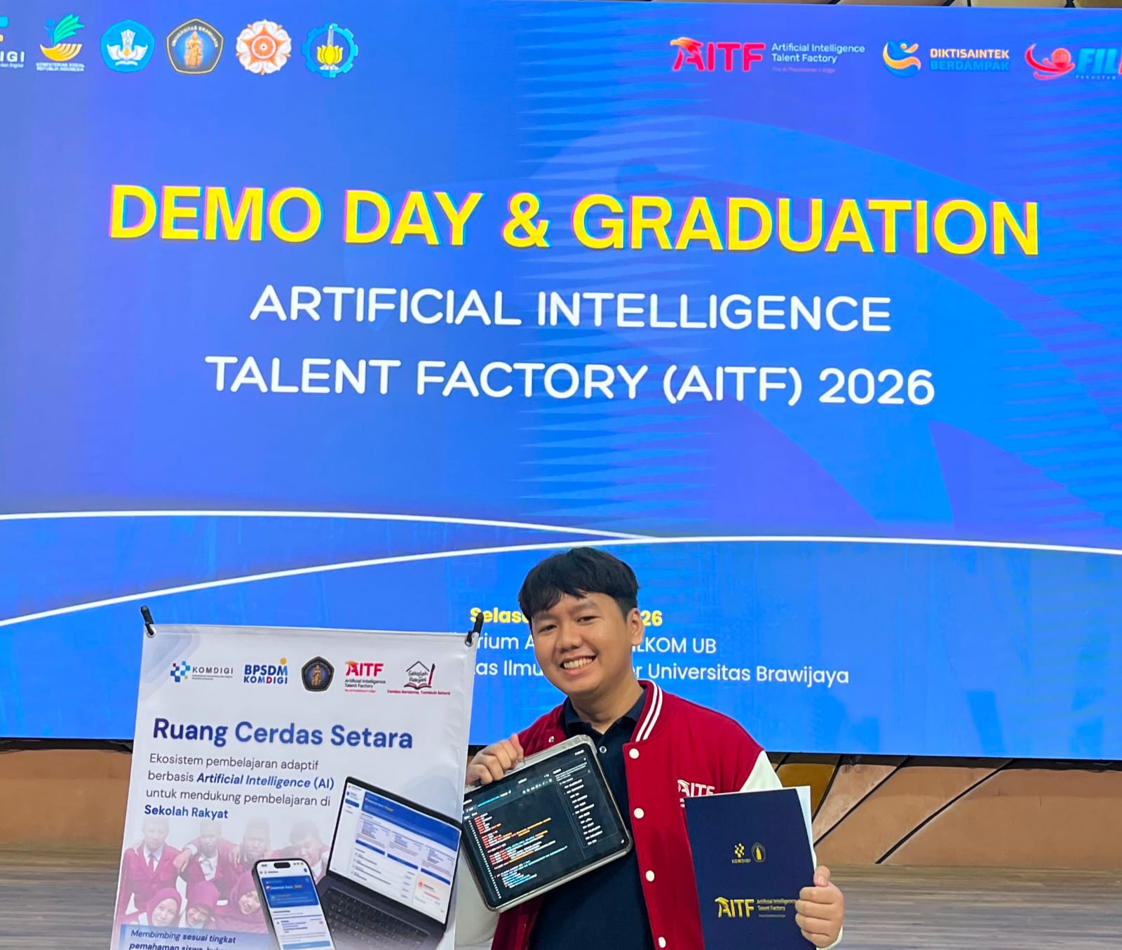 Khairuramdhani at the AITF Demo Day & Graduation, holding his team's project
