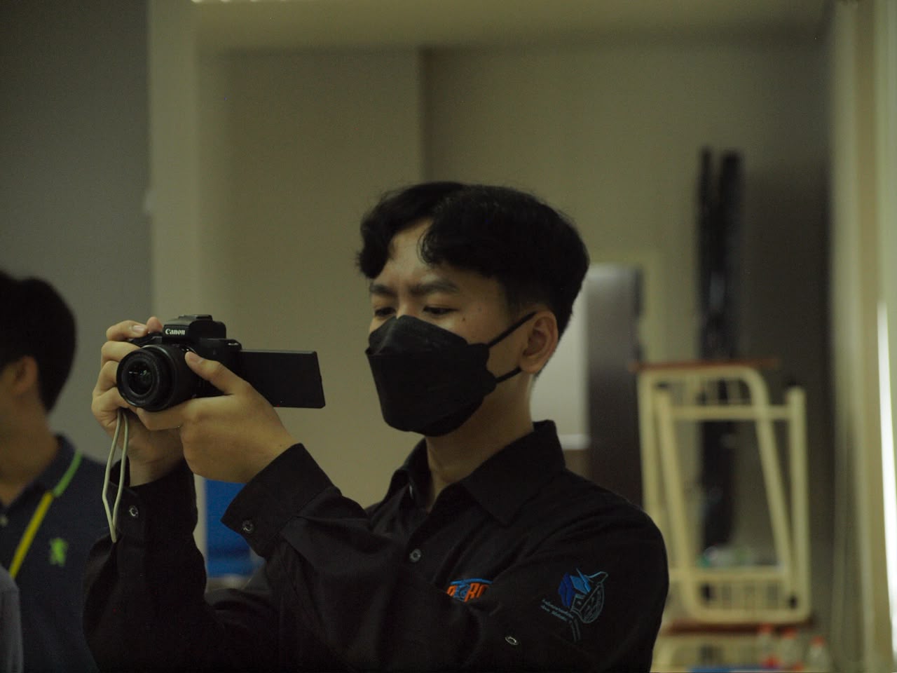 Khairuramdhani taking a photo with a Canon mirrorless camera